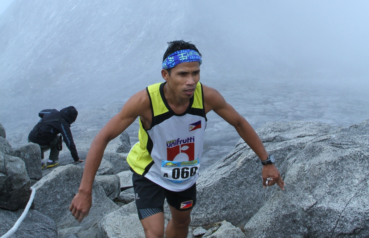 一位登山者站在神山顶峰