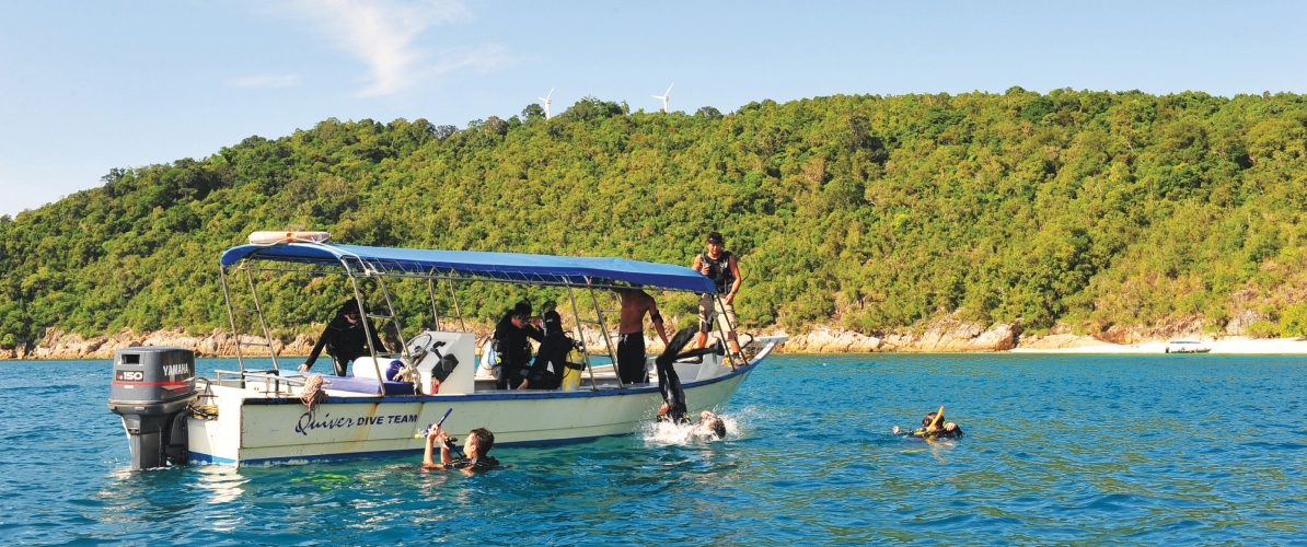 A group of scuba divers preparing for a dive at Pulau Kapas or Pulau Lang Tengah.